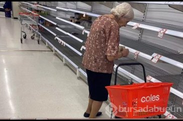 Yaşlı kadının yapayalnız, boş raflara bakarken çekilen görüntüsü yü...
