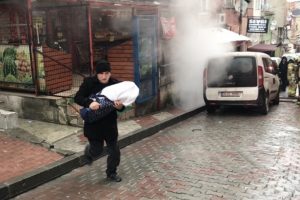 Bebeğiyle dumanların arasından çıktı