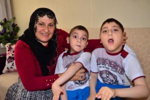 Engelli iki çocuğuna bebek gibi bakıyor