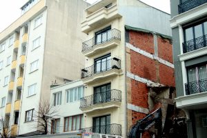 Yıkım çalışması yapan iş makinesi binaya zarar verdi