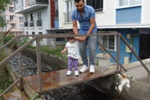 Bursa'da su kanalından geçerek apartmanlarına giriyorlar