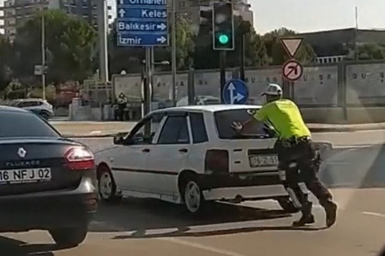 Bursa'da trafik polisi yolda kalan otomobili iterek, sürücüye yardım etti