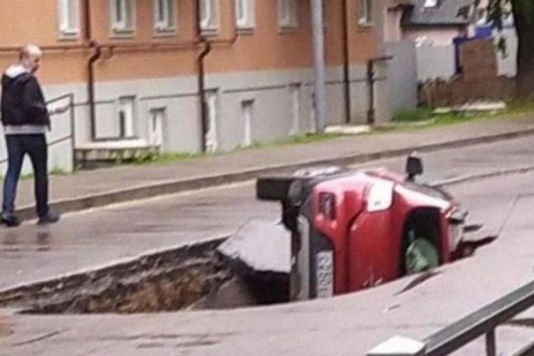 Otomobil asfaltın çökmesiyle çukura düştü