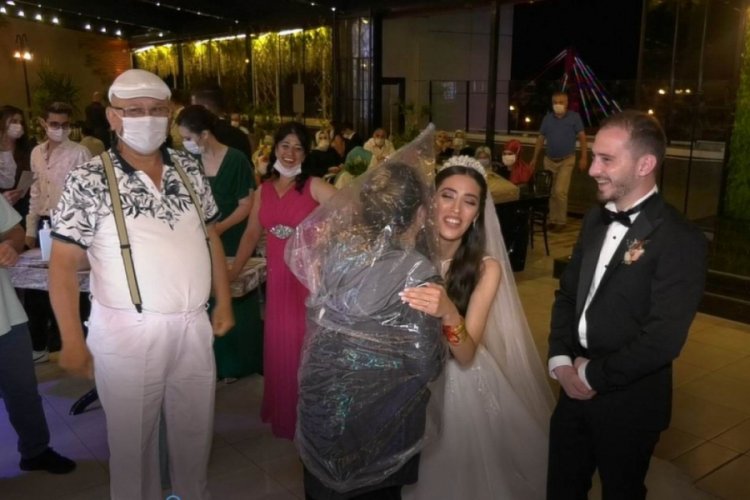 Kafasına poşet geçirip gelin ve damada sarıldı