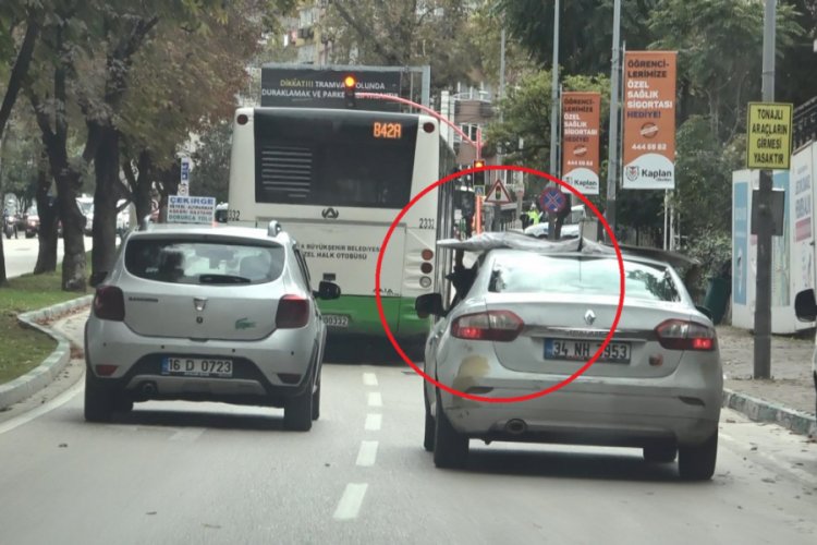 Bursa'da bir eliyle direksiyonu diğer eliyle otomobilinin üstündeki suntayı tutan sürücüye ceza