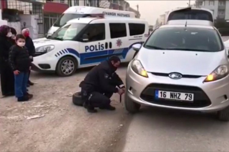 Bursa'da polis yolda kalan sürücünün otomobilinin lastiğini değiştirdi