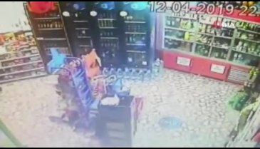 Çaldığı içki şişesini montuna saklayan hırsız kamerada