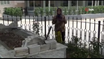 Yol ortasında kalan mezarın başında dua ediyorlar