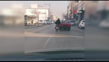 Bursa'da bozulan otomobilini motosiklet ile iterek tamire götürdü
