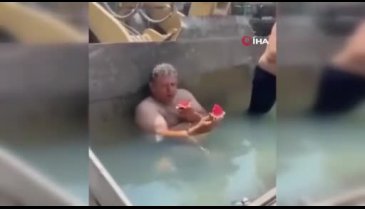 Bursa'da sıcaktan bunalan işçiler, kepçeyi havuza çevirdi