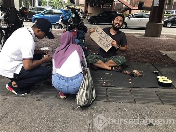 Bileklik satarak dünyayı geziyor