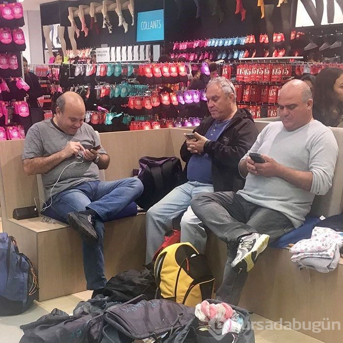 Alışveriş yapan kadınları bekleyen erkekler
