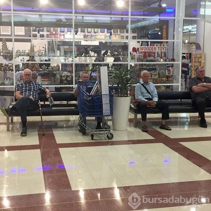 Alışveriş yapan kadınları bekleyen erkekler