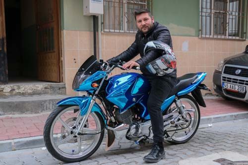 Modifiye motosikletini evinin salonuna park ediyor
