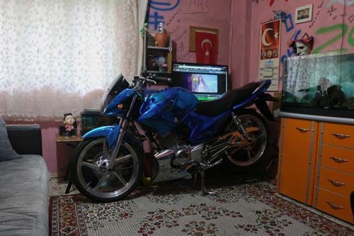 Modifiye motosikletini evinin salonuna park ediyor

