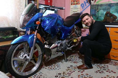 Modifiye motosikletini evinin salonuna park ediyor
