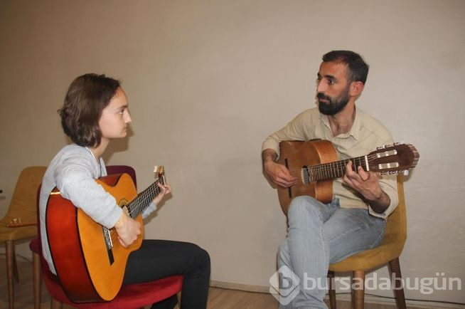 Müzisyen terzi minik ellere nota öğretiyor
