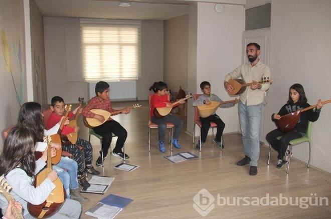 Müzisyen terzi minik ellere nota öğretiyor

