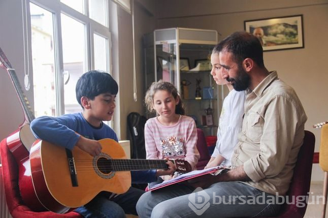 Müzisyen terzi minik ellere nota öğretiyor
