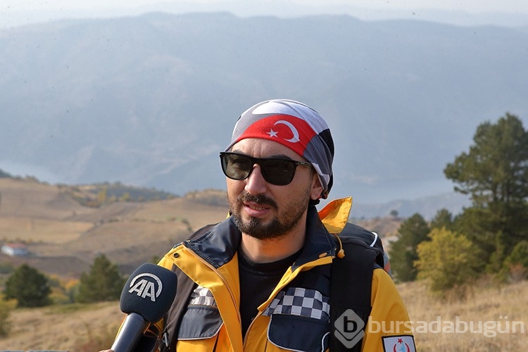 Yamaç paraşütünden açtığı afişle ambulanslara yol istiyor