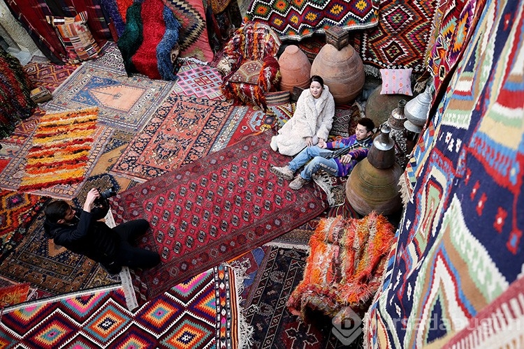 Halı mağazasını fotoğraf stüdyosuna çevirdi