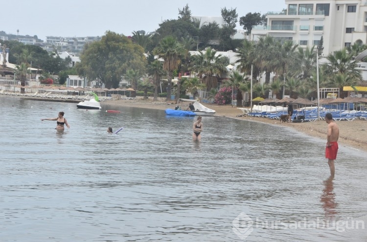 Turistler Muğla'da yağışlı havaya rağmen denize girdiler