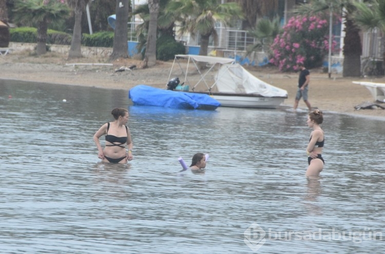 Turistler Muğla'da yağışlı havaya rağmen denize girdiler