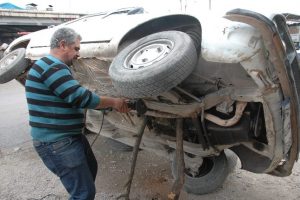 Otomobilini yan yatırıp tamir etti