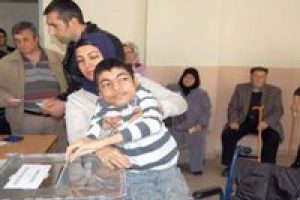 Annesinin kucağında oy kullandı