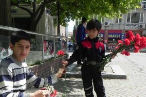 K&uuml;&ccedil;&uuml;k polisten ayakkabı boyacısı &ccedil;ocuğa karanfil
