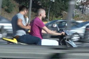 Motosikletlinin arkasında d&uuml;r&uuml;m yerken