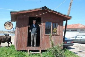 Deniz kıyısındaki barakada berberlik yapıyor