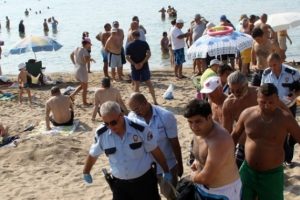 Plajdakiler kıyıdaki cesede aldırmaksızın y&uuml;zd&uuml;