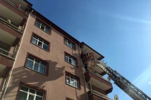 Balkon demirinde asılı kalan kızı itfaiye kurtardı