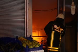 Alevler i&ccedil;inde yanan marketin sahipleri itfaiye erlerine saldırdı