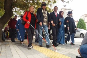Ellerinde beyaz baston ile y&uuml;r&uuml;d&uuml;ler