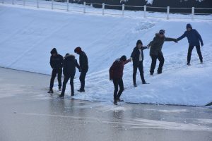 Bursa'da öğrenciler el ele tutuşup, buz tutan gölet üzerinde yürümeye çalıştı