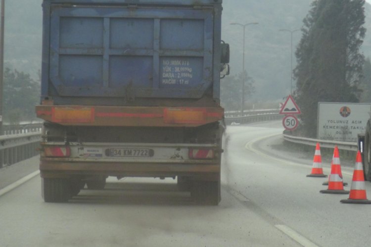Hafriyat kamyonu &uuml;zerindeki kum d&ouml;k&uuml;lerek ilerledi