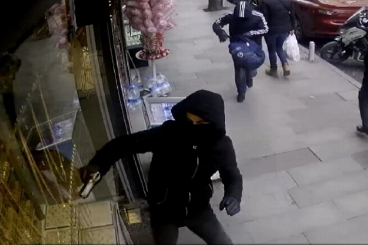 Y&uuml;zleri maskeli ve silahlı iki kişi kabzayla vitrin camını kırmaya &ccedil;alıştı