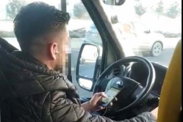 Minib&uuml;s şof&ouml;r&uuml; elinde telefonla trafikte