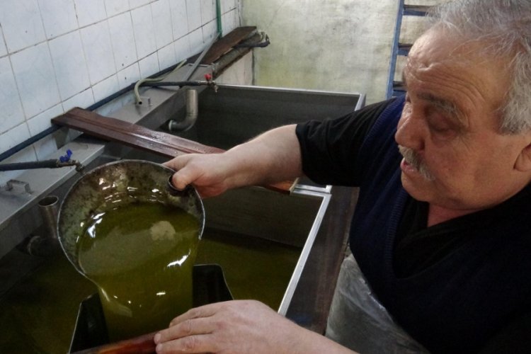 Kıvrak bilek hareketiyle zeytinyağını sudan ayırıyor