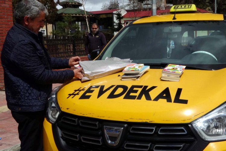Taksinin &ccedil;evresine 'evde kal' yazıp, kitap dağıttı