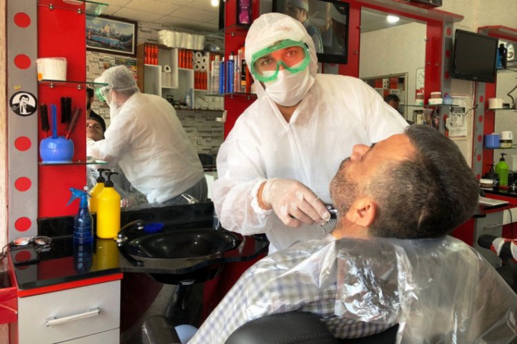 Koruyucu tulum giyip, g&ouml;zl&uuml;k ve maske takarak tıraş yaptı