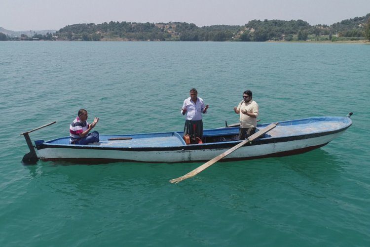 Su altında kalan mezarlığa sandalla giderek dua ediyorlar