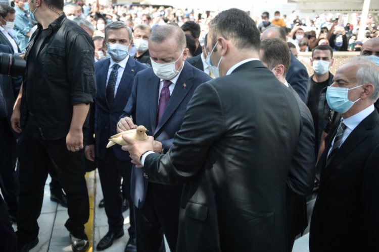 Cumhurbaşkanı Erdoğan, kuş yemi satıcısının ahşap g&uuml;vercinini imzaladı
