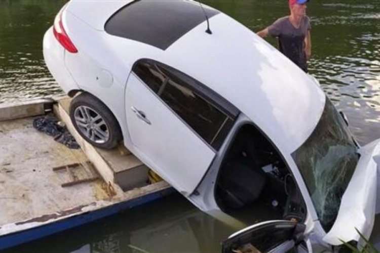 Otomobil nehir kenarındaki teknenin &uuml;zerine d&uuml;şt&uuml;