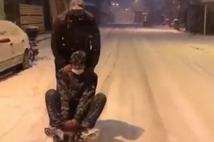Bursa'da buzlu yolda otomobile bağladıkları kızakla kaydılar