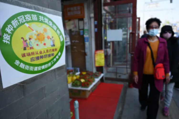 Pekin'de işletme kapılarına çalışanların aşılanma sayıları asıldı