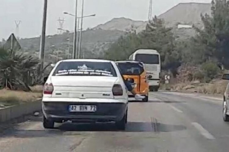 Seyir halindeki ara&ccedil;tan ayaklarını sarkıttı!