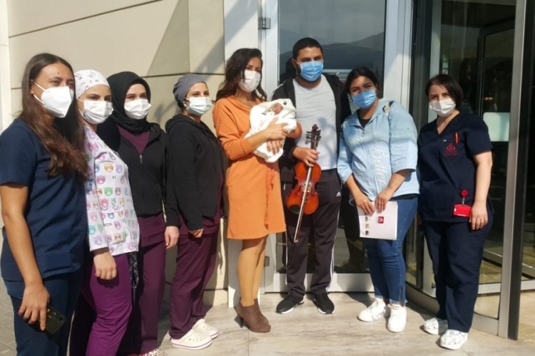 Bursa'da müzisyen baba, bebeğini hastane kapısında kemanla karşıladı